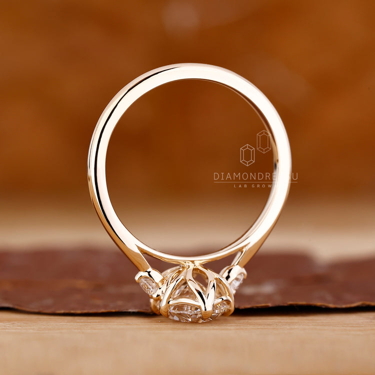 Oval diamond ring round side stones prong set.
