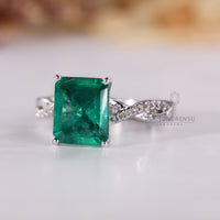 Emerald cut ring with round diamond pave band.

