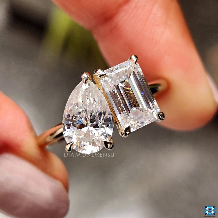 2 stone engagement ring featuring emerald and pear cut stones.