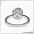 Side stone engagement ring with a cushion cut center and diamond accents.
