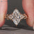 Marquise diamond ring round side stones design.