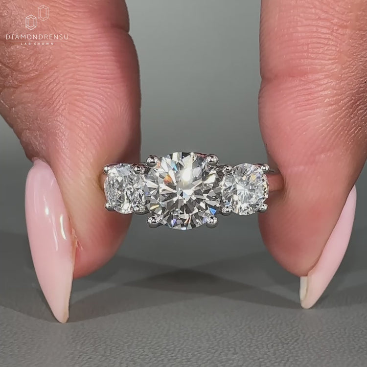 Trellis ring setting featuring a round diamond centre and custom side stones.
