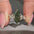 Green diamond ring with baguette and round side stones.
