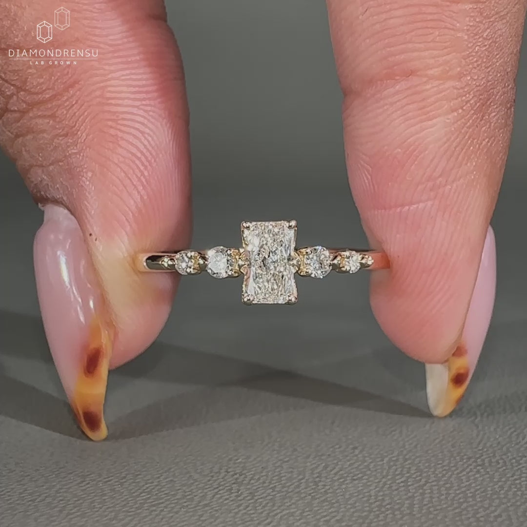 Radiant cut engagement ring with side stones.
