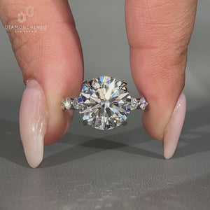 Blue oval lab diamond ring with heart side stones.

