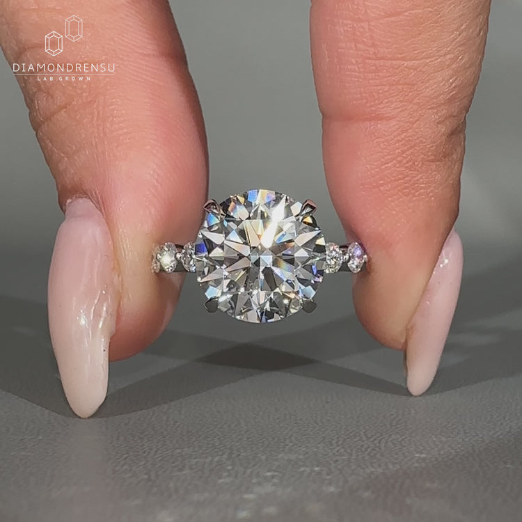 Blue oval lab diamond ring with heart side stones.
