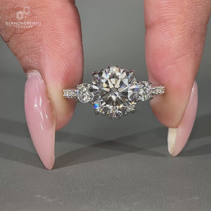Round cut diamond ring with pavé and milgrain setting in white gold.

