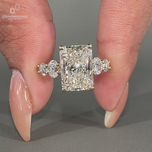 Yellow gold engagement ring with oval and round side stone.
