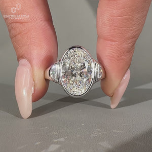 Oval cut three stone ring in bezel setting.
