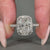 Round diamond halo ring with double claw prong setting.
