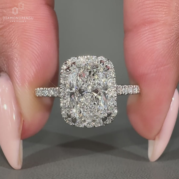 Round diamond halo ring with double claw prong setting.
