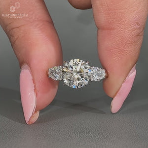 Round diamond ring three stone pear side stones set.

