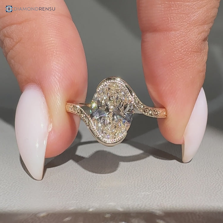 Oval diamond ring with Art Deco bypass design.