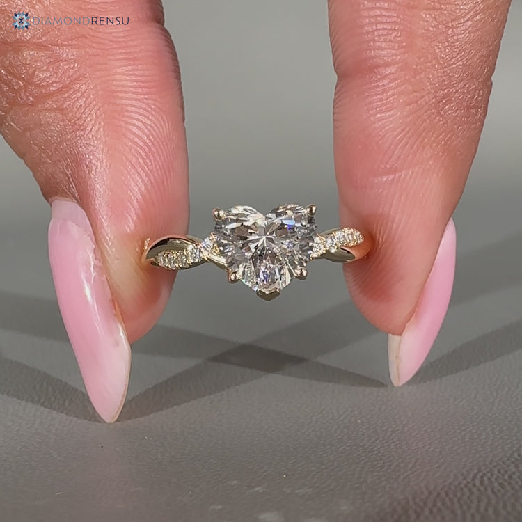 Heart diamond ring with round diamond pave accents.