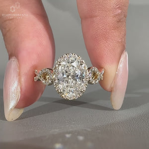 Twisted pave ring with round diamond halo setting in yellow gold.
