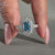 Halo engagement ring with blue radiant diamond ring.
