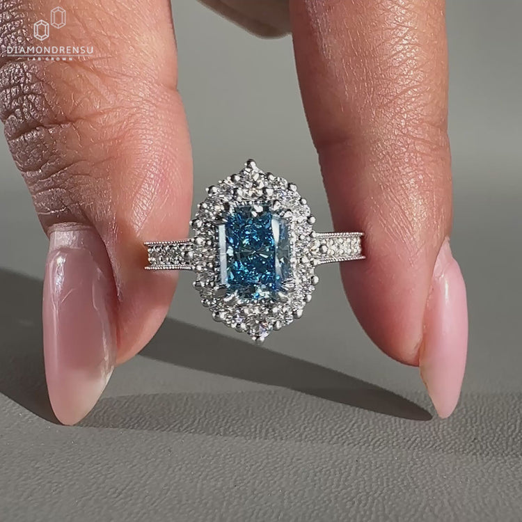 Halo engagement ring with blue radiant diamond ring.

