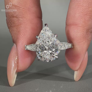 Pear cut diamond ring with milgrain setting and cathedral design.

