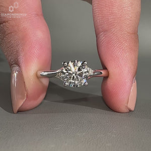 Split shank engagement ring with round cut side stones.
