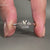 Split shank engagement ring with round cut side stones.
