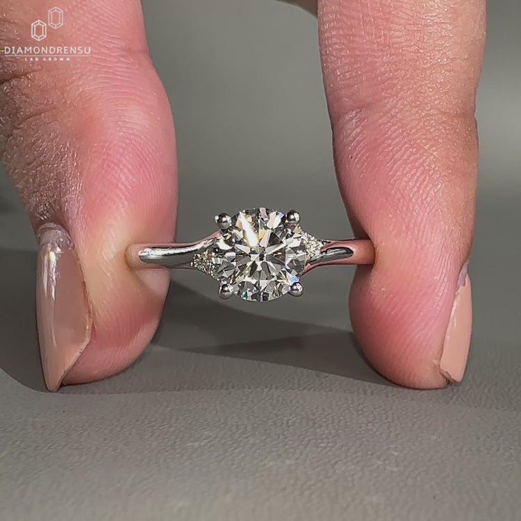 Split shank engagement ring with round cut side stones.
