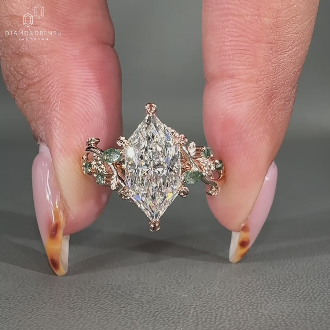 Marquise and round side stone with Moss Agate side diamonds.
