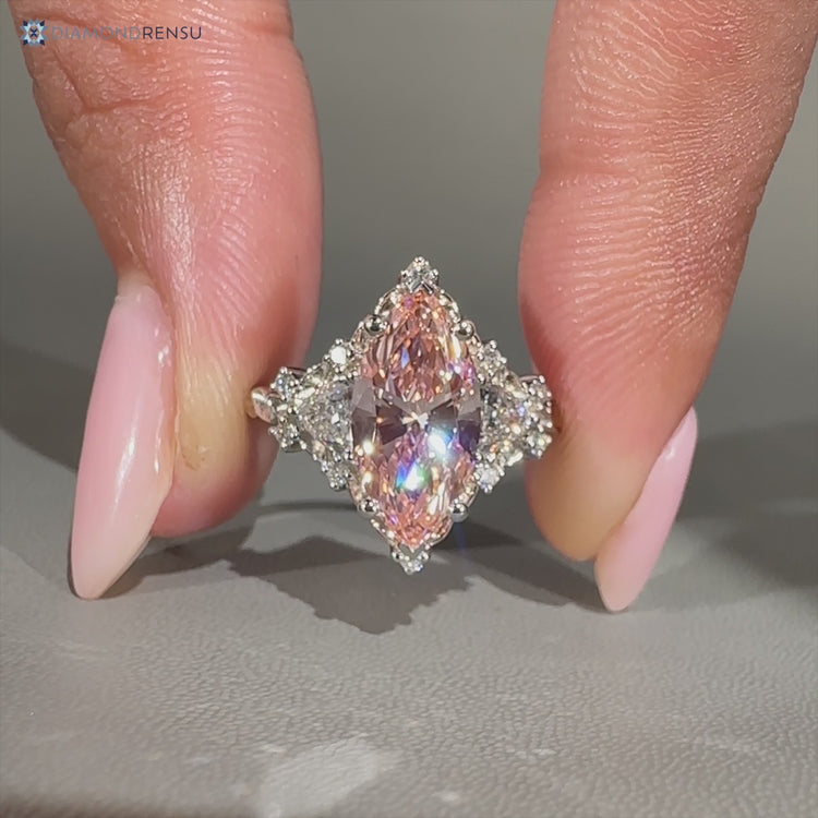 Pink marquise diamond ring with trillion side stones.