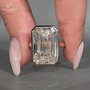 Bezel set solitaire diamond ring with emerald cut centre.