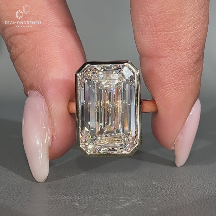 Bezel set solitaire diamond ring with emerald cut centre.