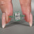 Round cut emerald ring featuring an emerald halo set in a handcrafted white gold band.
