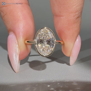 Oval diamond solitaire ring with bezel setting.