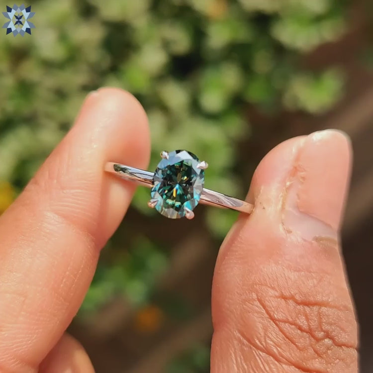 Solitaire ring with a unique greenish blue stone set in white gold.
