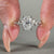 Round side stone ring featuring an elongated cushion cut diamond centre.
