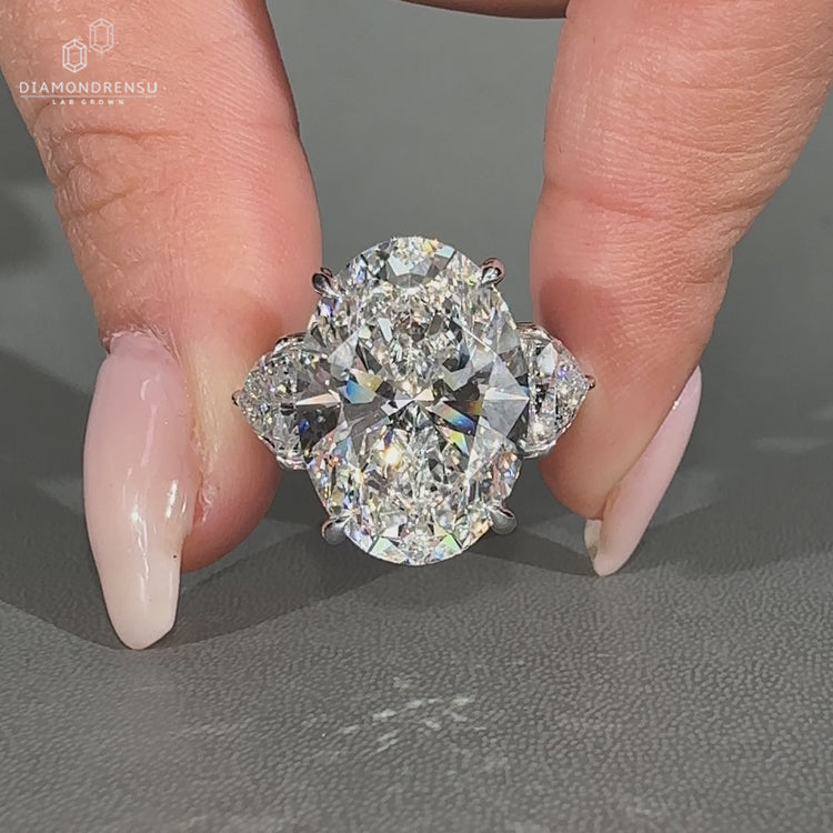 Oval diamond ring featuring trillion cut diamond side stones.