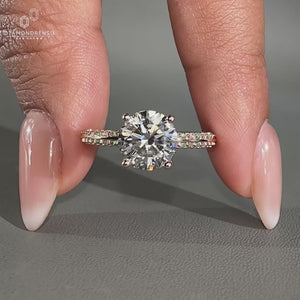 Round cut diamond ring with pavé band and knife edge design.

