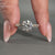Round cut diamond ring with pavé band and knife edge design.
