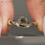 Cushion cut diamond solitaire ring with four claw prongs.