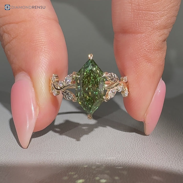 Green diamond ring with marquise and round side stones.