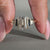 Emerald cut center diamond ring with tapered shank setting.
