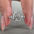 Pear and round diamond ring crafted with round side stones in a prong setting.
