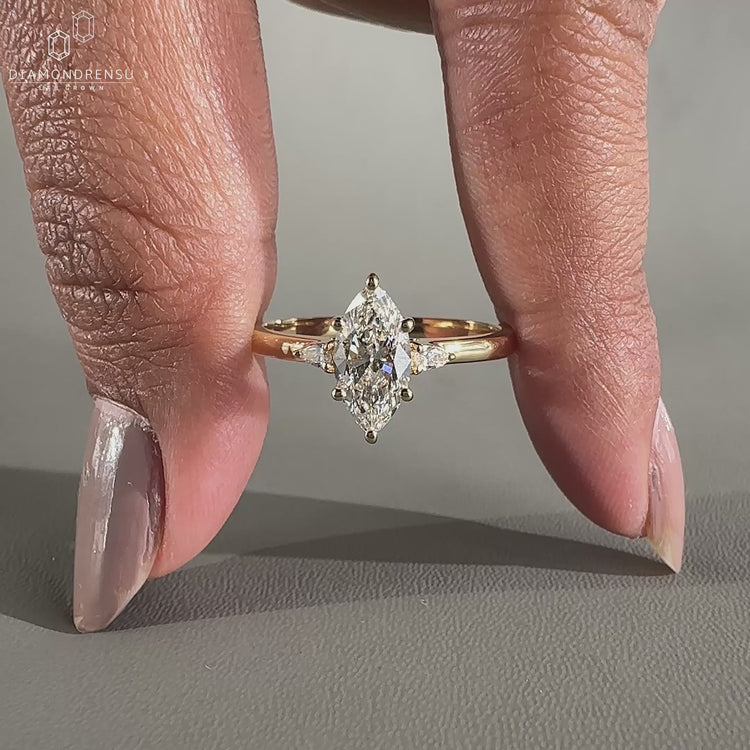 Marquise cut diamond ring in pear side stone ring.
