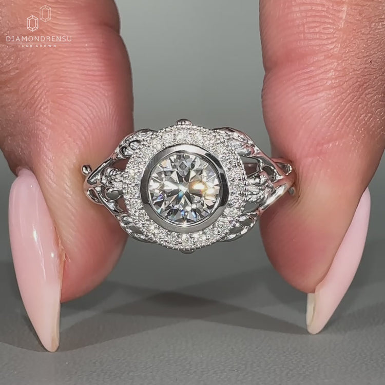 Halo diamond engagement ring in white gold bezel setting.
