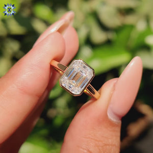 Emerald cut engagement ring in a sleek bezel set design.