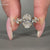 Oval diamond ring with marquise side stones and hidden halo in yellow gold.

