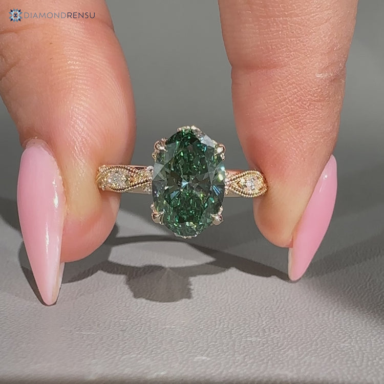 Green diamond oval ring with marquise and round accents.
