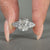 Hidden halo engagement ring with pear side stone.
