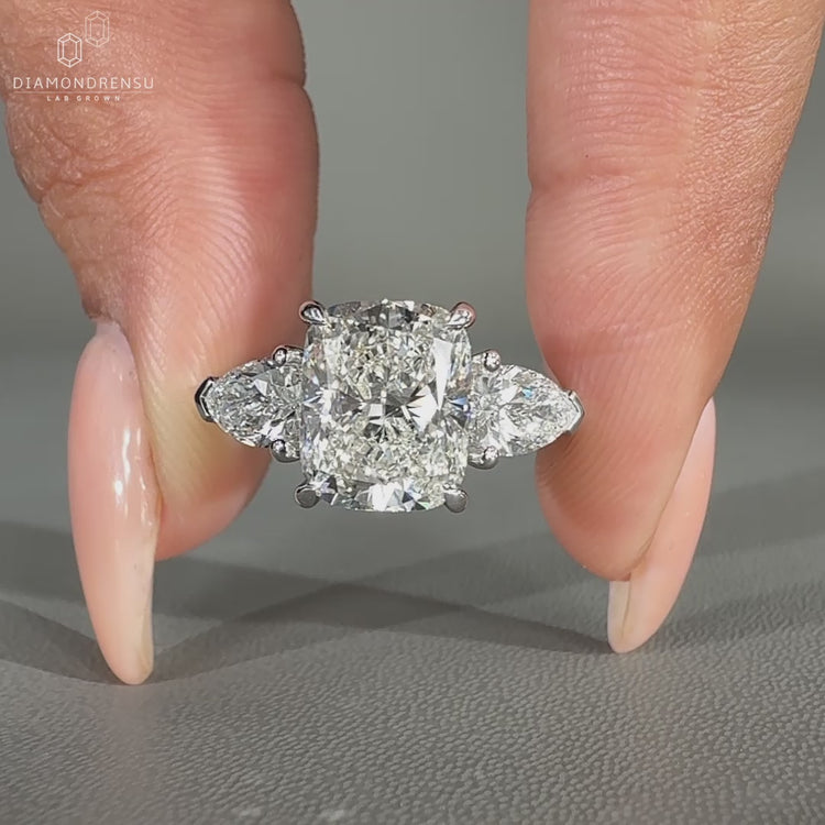 Hidden halo engagement ring with pear side stone.
