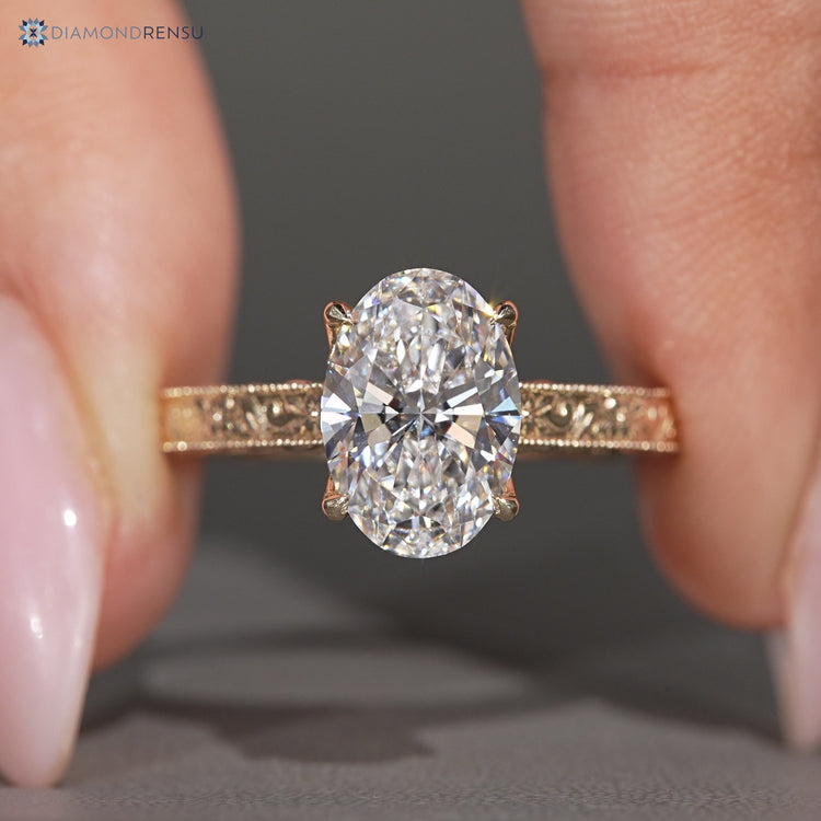 Oval diamond ring with milgrain detailing.