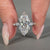 Marquise diamond ring with shared prong pave setting.