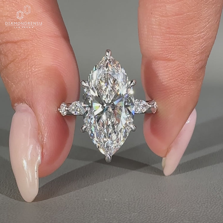 Marquise diamond ring with shared prong pave setting.